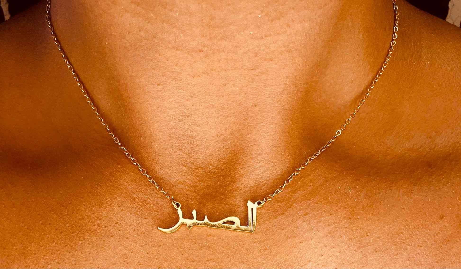 Close-up of the Patience tarnish-proof 18K gold plated Arabic necklace, showcasing intricate Arabic calligraphy design.