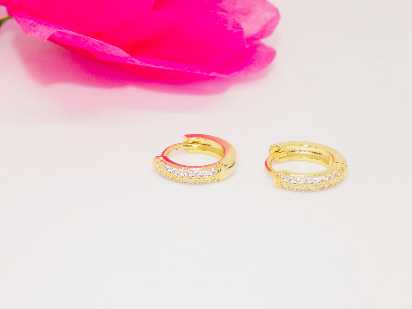 Close-up of tarnish-proof 14K gold plated geometric huggie earrings featuring dazzling cubic zirconia accents.