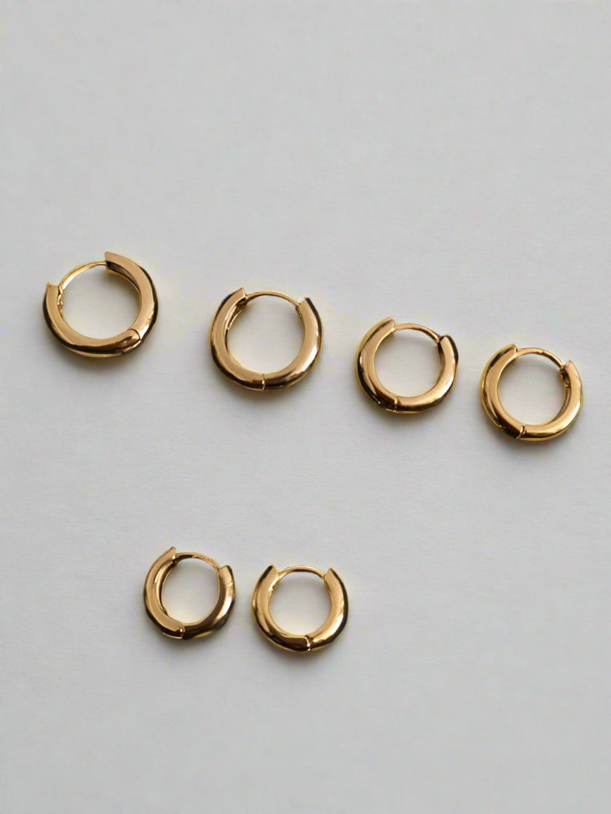 Close-up of tarnish-proof 14K gold plated geometric huggie earring, showcasing sleek minimalist design.