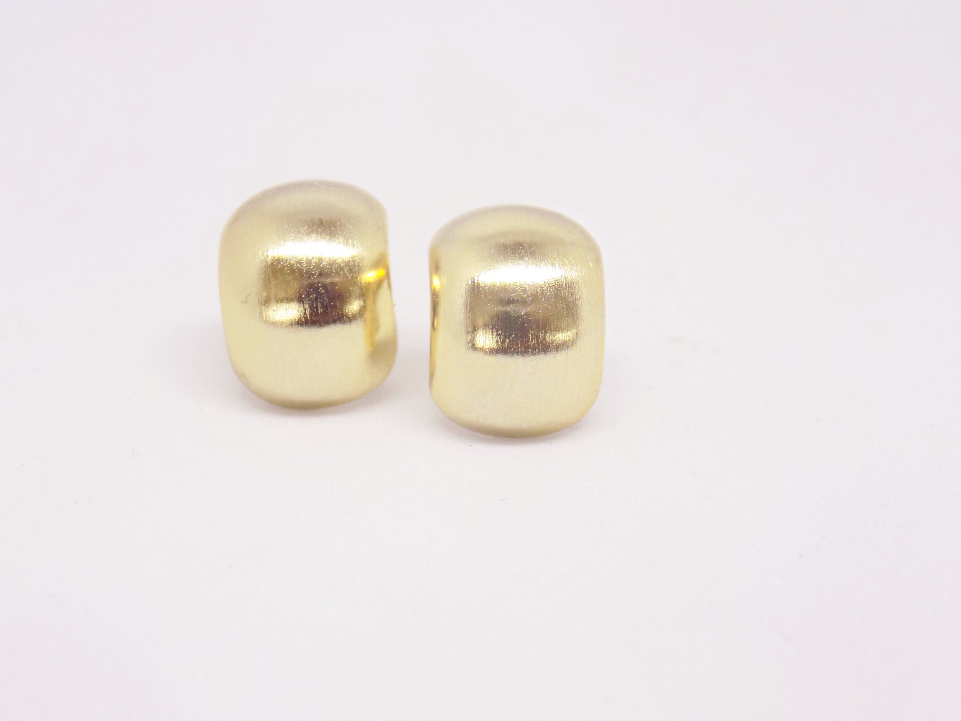 Close-up of tarnish-proof 14K gold plated smooth circular stud earring, showcasing sleek minimalist design.