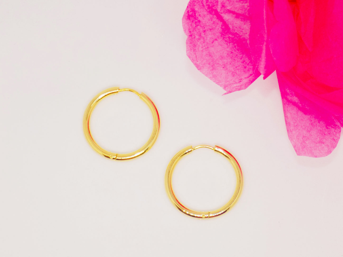 Close-up of tarnish-proof 14K gold plated minimalist huggie earrings, featuring a sleek round design for everyday wear.
